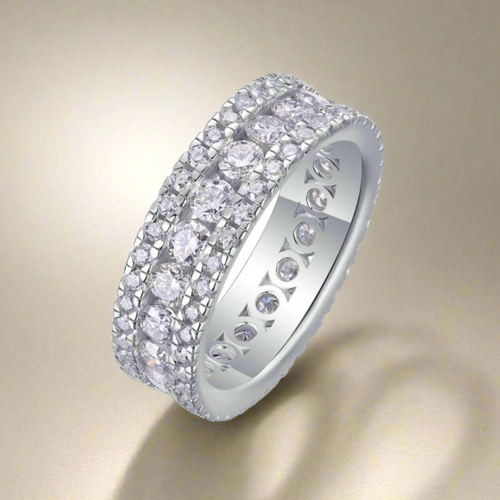 Silver ring with multiple rows of diamonds on a white background